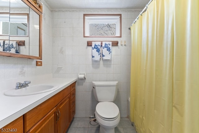 bathroom featuring tile patterned flooring, a shower with curtain, vanity, toilet, and tile walls