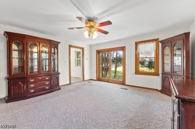 interior space with light carpet and ceiling fan