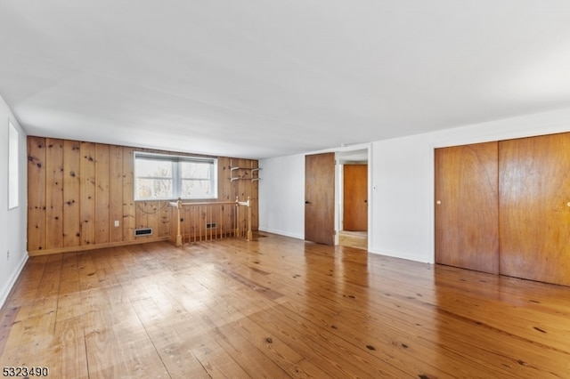 spare room featuring wooden walls and wood-type flooring