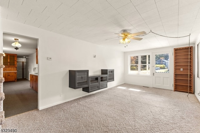 unfurnished living room featuring carpet and ceiling fan