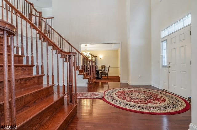 entrance foyer featuring a high ceiling, hardwood / wood-style flooring, and a notable chandelier