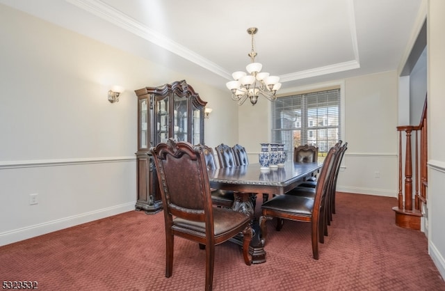 carpeted dining room with crown molding, a tray ceiling, and a chandelier