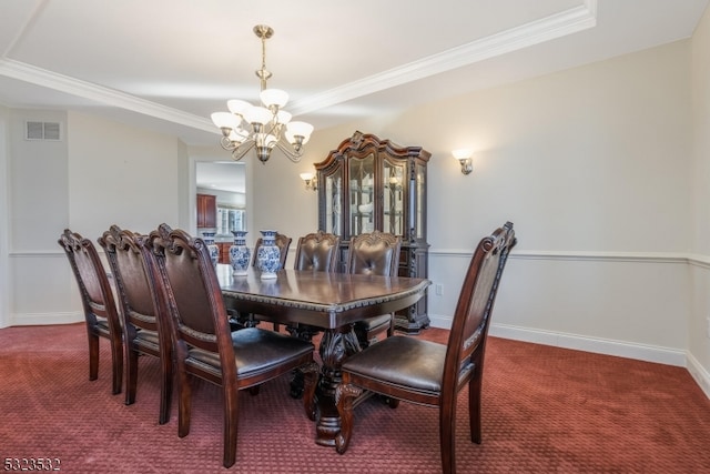 dining room featuring carpet flooring, a notable chandelier, a raised ceiling, and crown molding