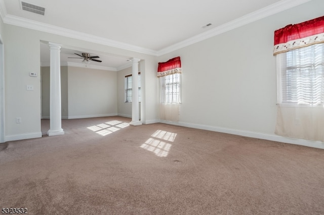 carpeted empty room with ceiling fan, a healthy amount of sunlight, crown molding, and decorative columns