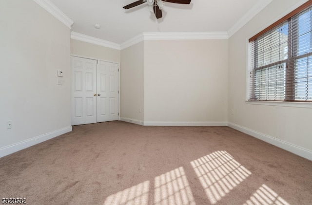 spare room with light colored carpet, ceiling fan, and crown molding