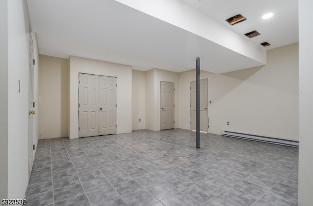 basement featuring tile patterned floors and a baseboard heating unit