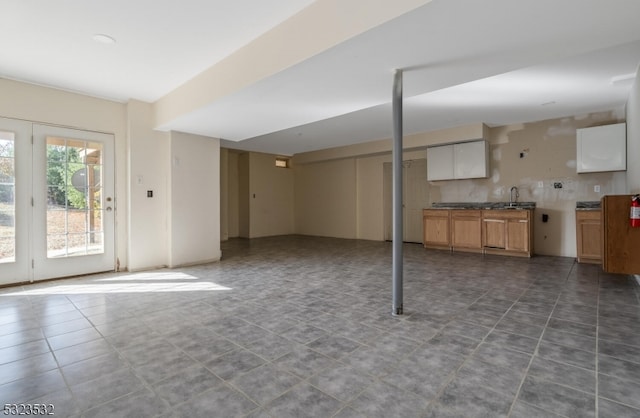 basement with dark tile patterned floors and sink