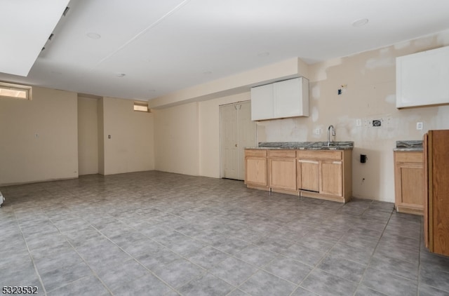 kitchen with white cabinetry, sink, and light tile patterned floors