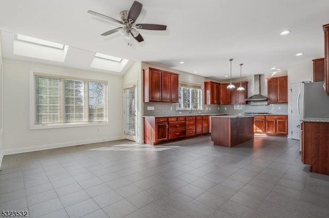 kitchen featuring decorative backsplash, a center island, wall chimney exhaust hood, and pendant lighting