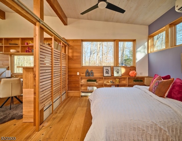 bedroom with a wall unit AC, wooden walls, light hardwood / wood-style flooring, and ceiling fan