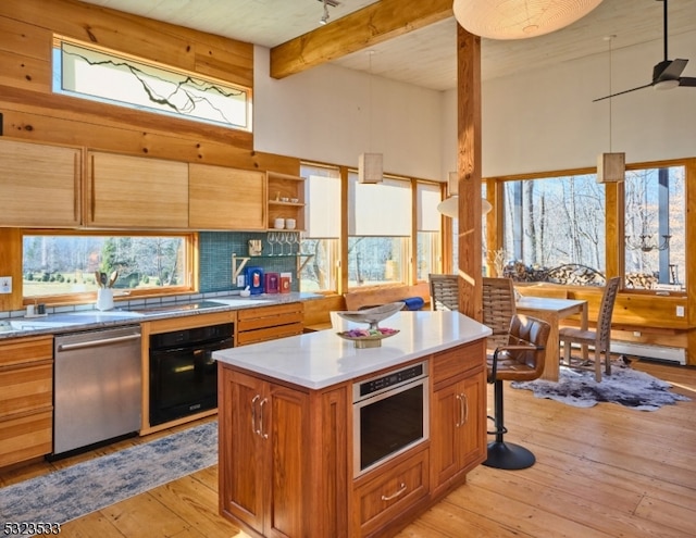 kitchen featuring pendant lighting, stainless steel appliances, ceiling fan, and light hardwood / wood-style floors