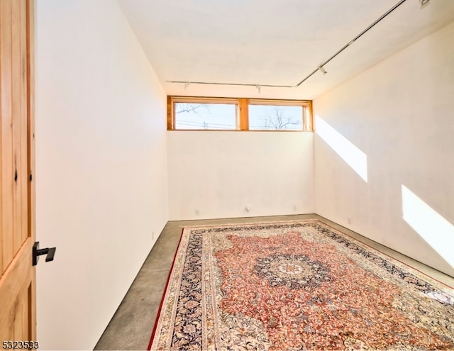 spare room with concrete floors and track lighting