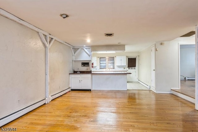 kitchen with baseboard heating, kitchen peninsula, light hardwood / wood-style flooring, and white cabinets