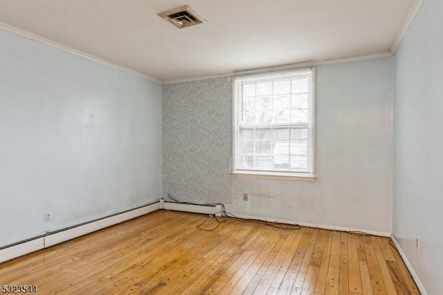 empty room with hardwood / wood-style floors, a baseboard heating unit, and crown molding