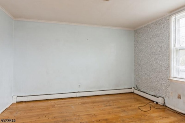 unfurnished room with crown molding, a baseboard heating unit, and hardwood / wood-style flooring