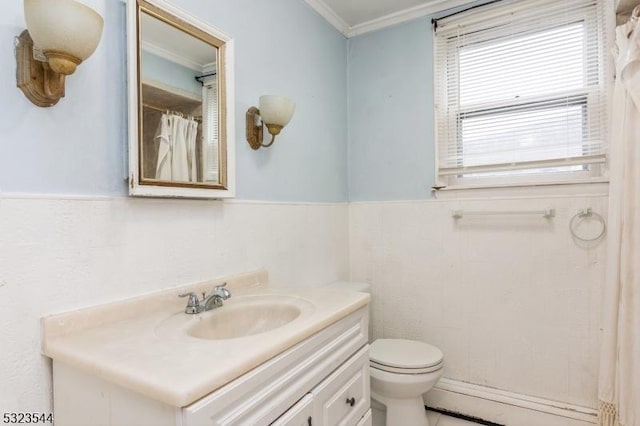 bathroom featuring toilet, vanity, and ornamental molding