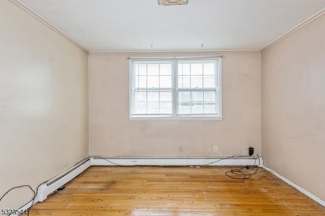 spare room with light hardwood / wood-style flooring, ornamental molding, and a baseboard heating unit