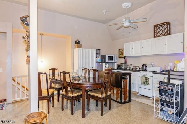 dining room with ceiling fan and high vaulted ceiling