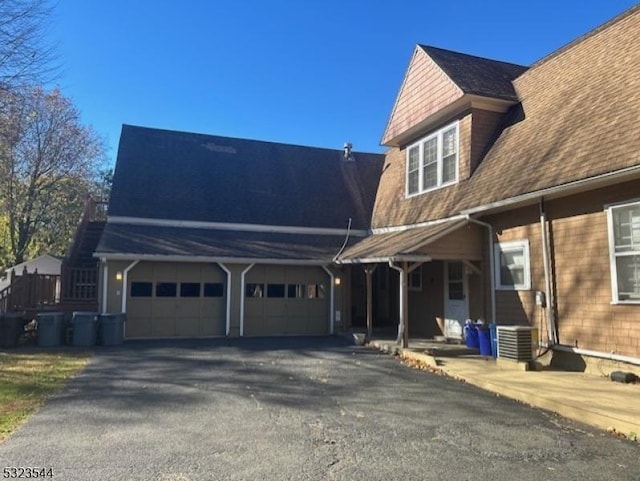 view of side of property featuring central AC and a garage