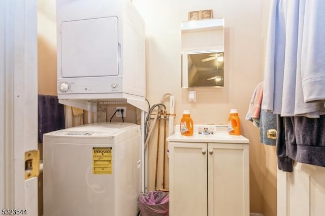 laundry area with ceiling fan, sink, and stacked washer and clothes dryer