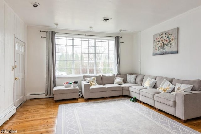 living room with wood-type flooring and a baseboard heating unit