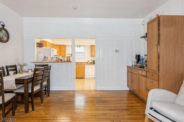 dining area featuring light hardwood / wood-style flooring and crown molding