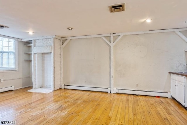 interior space featuring a baseboard radiator and light hardwood / wood-style flooring