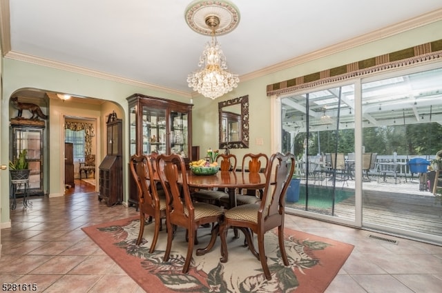 dining room featuring light tile patterned floors, an inviting chandelier, and ornamental molding