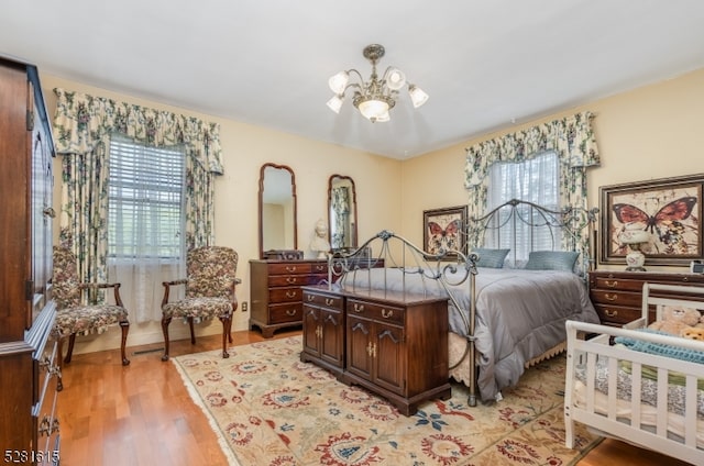 bedroom with light wood-type flooring and a chandelier