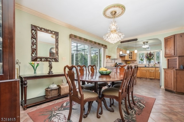 tiled dining area with crown molding and a notable chandelier