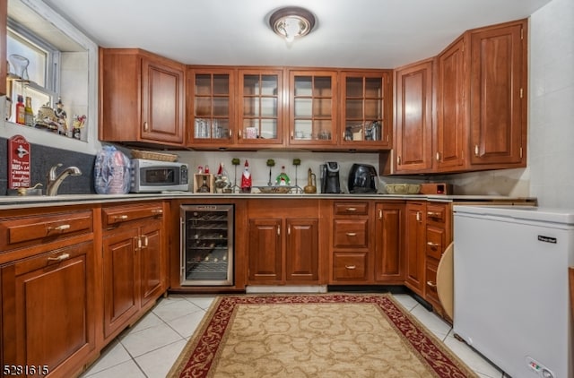 kitchen with light tile patterned flooring, white fridge, and wine cooler