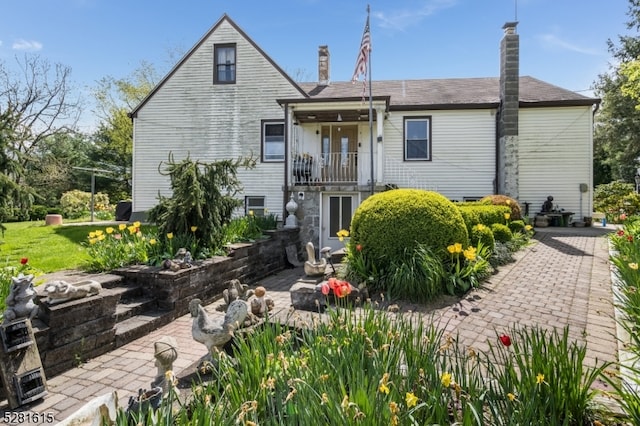 rear view of house with a balcony and a patio