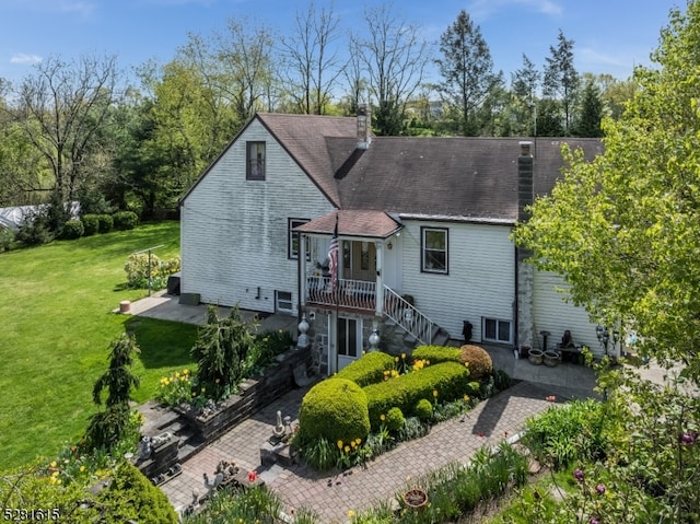 back of property featuring a lawn and a patio