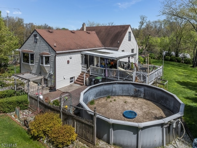 rear view of property with a wooden deck and a yard