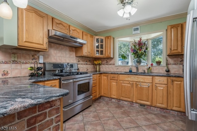 kitchen featuring dark stone counters, decorative backsplash, light tile patterned floors, and stainless steel appliances