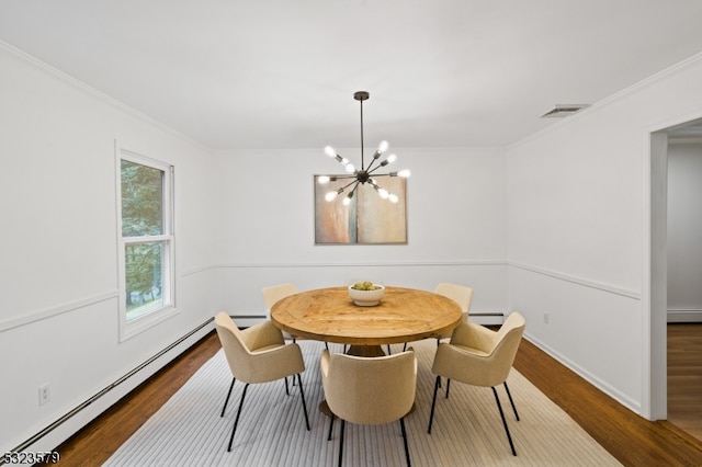 dining area with a chandelier, hardwood / wood-style floors, crown molding, and a baseboard heating unit