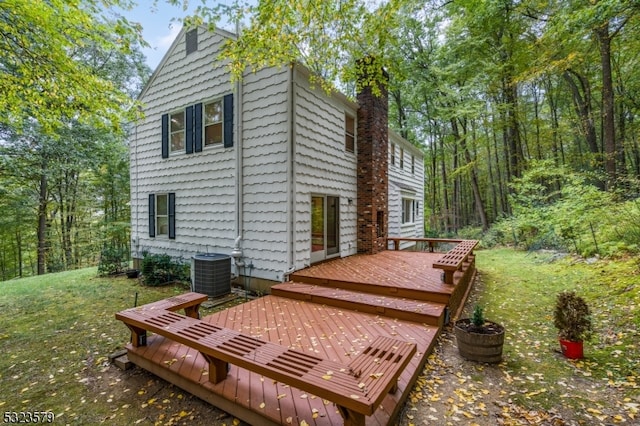 rear view of house featuring cooling unit, a lawn, and a wooden deck