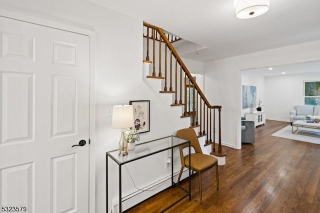 stairs featuring baseboard heating and hardwood / wood-style floors