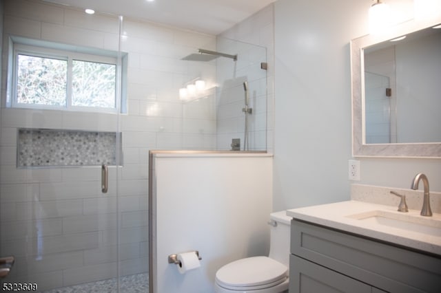 bathroom featuring vanity, toilet, and an enclosed shower