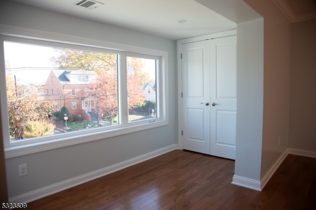 unfurnished bedroom featuring dark wood-type flooring and a closet