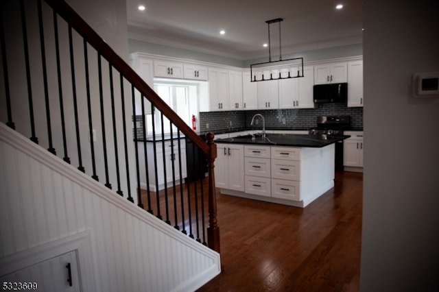 kitchen featuring black appliances, dark hardwood / wood-style flooring, white cabinetry, and hanging light fixtures