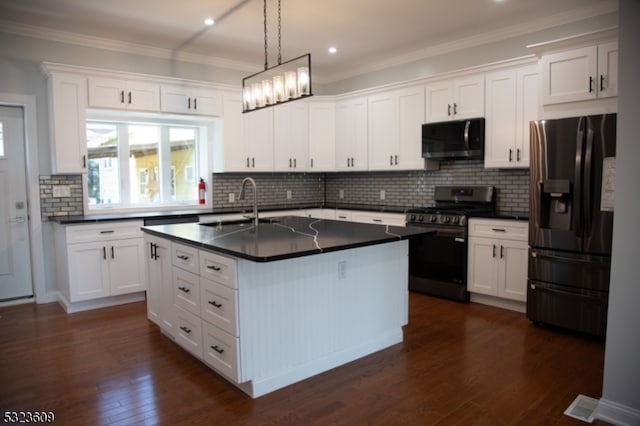 kitchen featuring appliances with stainless steel finishes, an island with sink, hanging light fixtures, white cabinets, and dark wood-type flooring