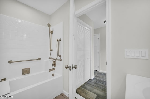 bathroom with wood-type flooring and tub / shower combination