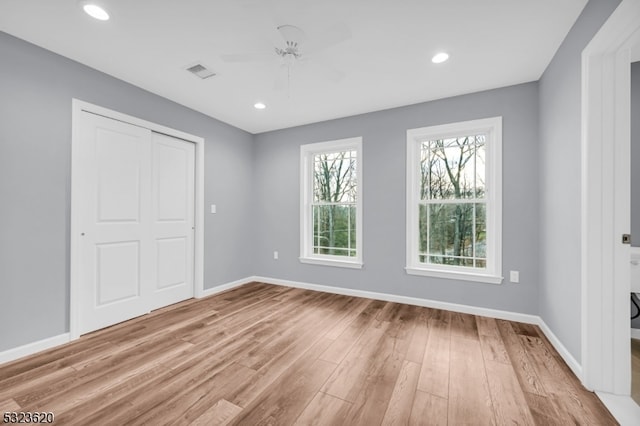 unfurnished bedroom featuring light wood-type flooring, a closet, and ceiling fan