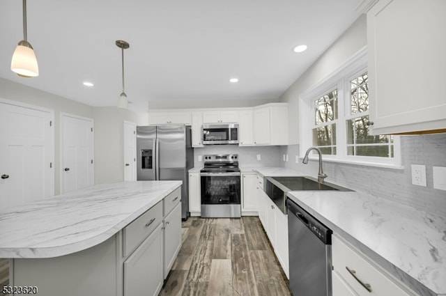 kitchen with white cabinetry, dark hardwood / wood-style flooring, hanging light fixtures, and appliances with stainless steel finishes