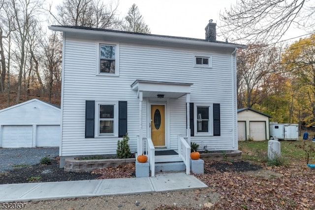 view of front of home featuring a garage and an outbuilding