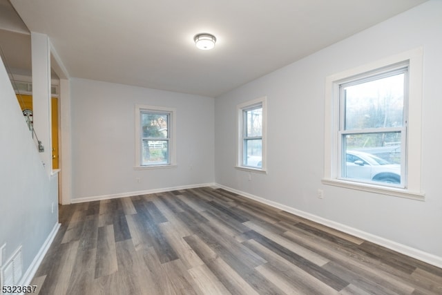 spare room featuring a wealth of natural light and dark hardwood / wood-style flooring