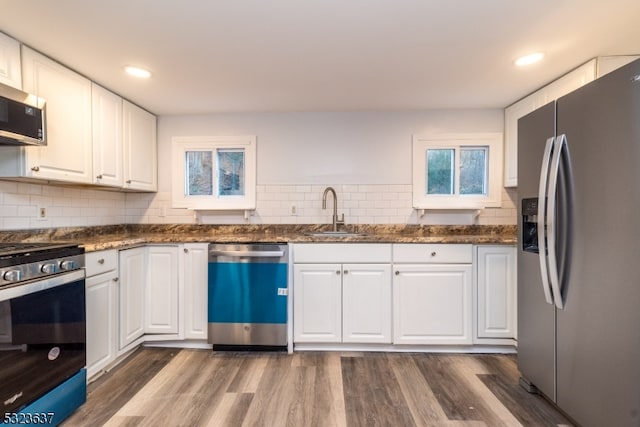 kitchen featuring sink, appliances with stainless steel finishes, tasteful backsplash, white cabinets, and dark hardwood / wood-style flooring