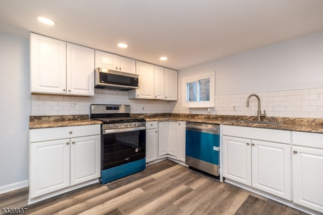 kitchen featuring stainless steel appliances, white cabinetry, and dark wood-type flooring