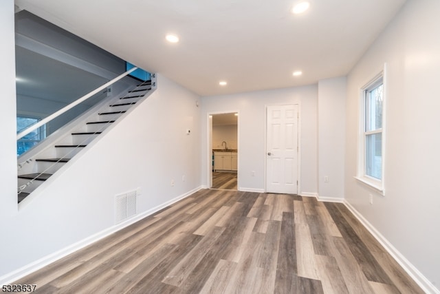 basement featuring hardwood / wood-style flooring and sink